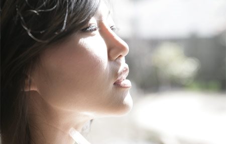 Mulher asiática olhando para o sol