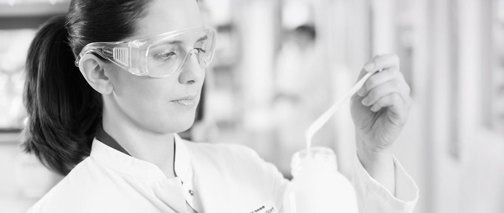 Cientista com óculos de proteção testando uma fórmula
