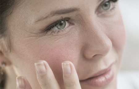 Mulher tocando o rosto com a mão