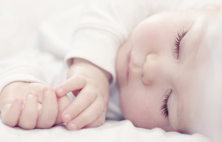 Bebê em posição de dormir. 