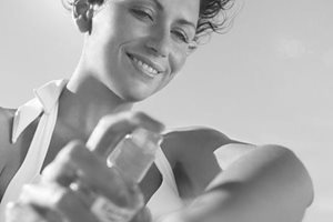 Mulher aplicando protetor solar no braço